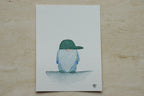 Aquarelle originale encadrée d'un gnome à casquette verte, style enfantin et tons doux.